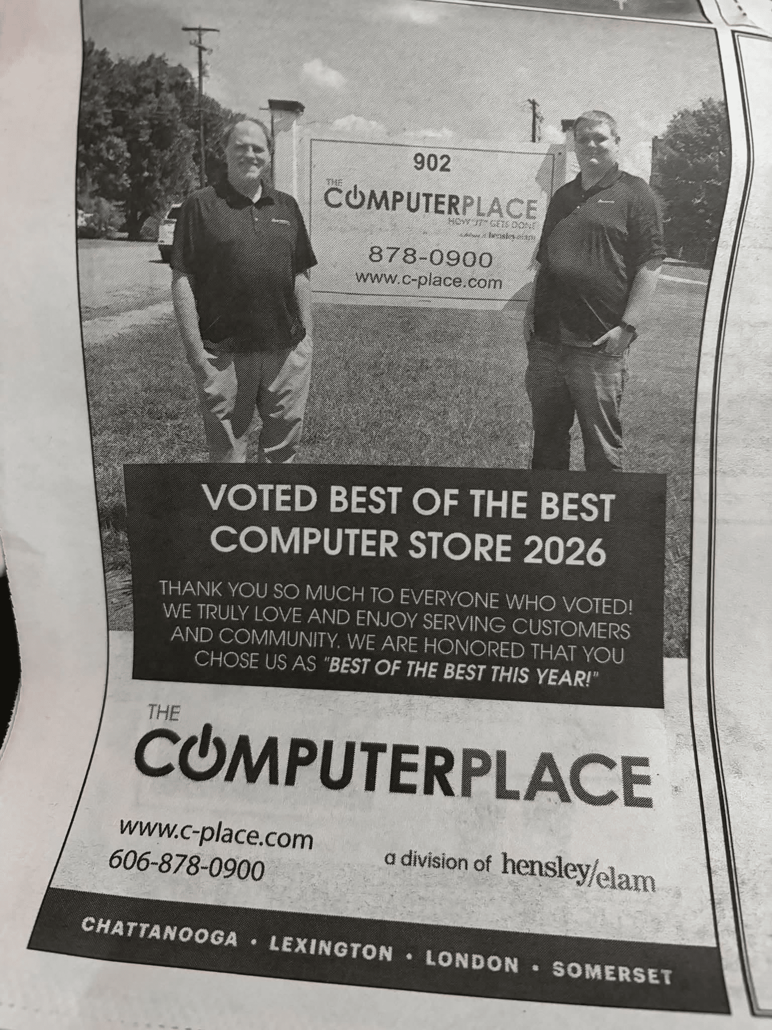 The Computer Place team beside the 902 West Fifth Street sign in a 2026 Best of the Best Computer Store newspaper announcement